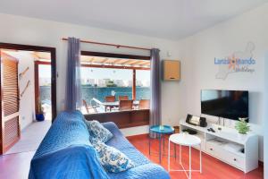 salon z niebieską kanapą i telewizorem w obiekcie Vivienda Vacacional Del Mar w mieście Playa Blanca