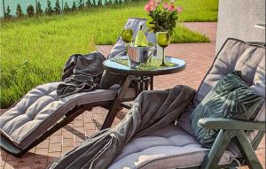 a table with two chairs and two glasses of wine at Beautiful Home In Slowienkowo in Skrzeszewo