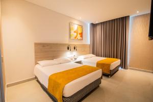 a hotel room with two beds and a window at Hotel Zi One Luxury in Cartagena de Indias