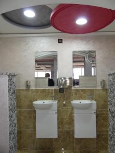 a bathroom with two sinks and two mirrors at Dar Diafa Chez Anaam in Er Rachidia