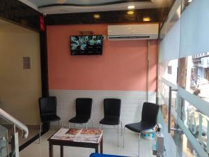 a waiting room with chairs and a table and a tv at Hotel Golden Nest Popular Residency in Mumbai