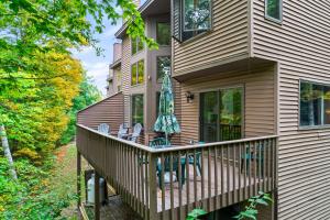 a home with a deck with chairs and tables at Gore Village Townhome #16 in North Creek