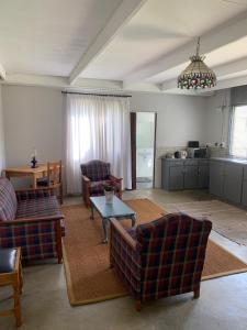 a living room with two couches and a table at Shabach Farm in Hartebeest Rivier