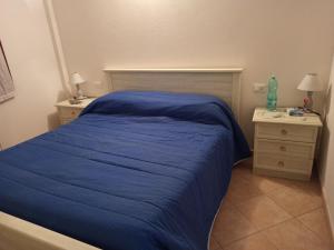 a bedroom with a blue bed and two night stands at sa janna in Orosei
