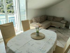 a living room with a table and a couch at Apartments Uvala Murtar in Jezera