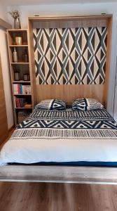 a bed with a wooden headboard in a bedroom at Cosy studio le Garden ensoleillé in Cabourg