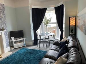 a living room with a leather couch and a table at Seaview Apartment with parking in Exmouth
