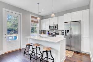 a kitchen with white cabinets and a counter with stools at The Darby House in Charleston