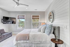 a white bedroom with a bed and a couch at The Darby House in Charleston