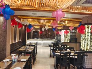 uma sala de jantar com mesas e balões no tecto em HOTEL ORANGE INN em Patna