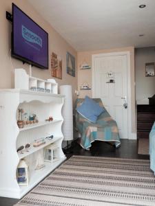 um quarto com uma cama e uma televisão na parede em Nannys Nook whitstable kent em Whitstable