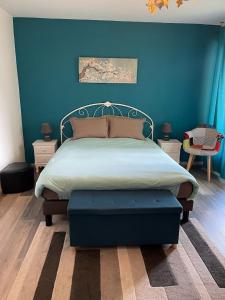 a bedroom with a bed with a blue wall at La Colonne in Obernai