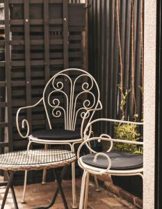 a wrought iron chair and two chairs on a balcony at Nannys Nook whitstable kent in Whitstable
