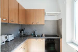 a kitchen with wooden cabinets and a sink and a dishwasher at Casa Serena by Quokka 360 - close to the shopping centre in Grancia