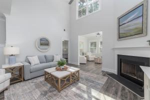 a living room with a couch and a fireplace at LUXURY BEACH HOUSE W/ BACKYARD OASIS. HEATED POOL. in Hilton Head Island