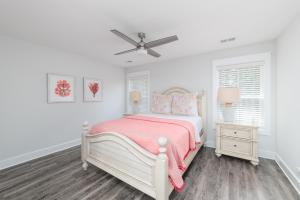 a white bedroom with a bed and a ceiling fan at LUXURY BEACH HOUSE W/ BACKYARD OASIS. HEATED POOL. in Hilton Head Island +12 photos