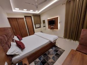 a small bedroom with a bed and a couch at HOTEL KAILASH in Deoria