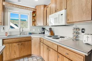 a kitchen with wooden cabinets and a stove top oven at Sand Castle Villa in Rockaway Beach +46 photos