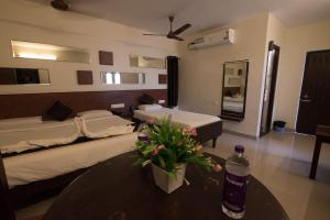 a hotel room with two beds and a table with a bottle of water at Arunik Inn in Puducherry