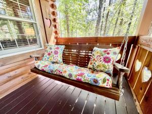 un columpio con almohadas en el porche en Snoozers Hollow cabin, en Sevierville