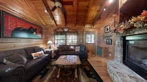 sala de estar con sofá y chimenea en Snoozers Hollow cabin, en Sevierville