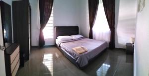 Schlafzimmer mit einem Bett und einem Fenster in der Unterkunft Wipah Guest House in Kampung Lundang, Kota Bharu in Kota Bharu