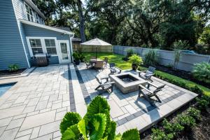 a backyard with a patio with a fire pit at LUXURY BEACH HOUSE W/ BACKYARD OASIS. HEATED POOL. in Hilton Head Island