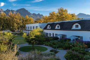 a building with a garden and mountains in the background at Erinvale Estate Hotel & Spa in Somerset West
