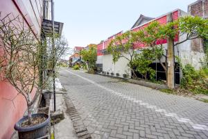 a cobblestone street in an alley with trees and buildings at OYO 91795 Kos Jeehel Syariah in Sidoarjo