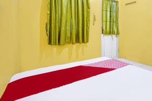 a bedroom with a bed with a red and white blanket at OYO 91795 Kos Jeehel Syariah in Sidoarjo