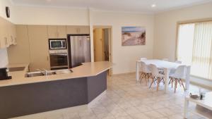 a kitchen and dining room with a table and chairs at Victor Central Cottage Perfect Location in Victor Harbor