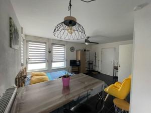 sala de estar con mesa y sillas amarillas en Le Beffroi, en Obernai