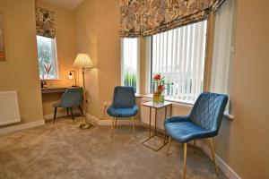 two chairs and a table in a room with a window at Moat House in Rawtenstall
