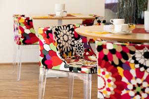 a dining room table with chairs covered in flowers at STAY.inn Comfort Art Hotel Schwaz in Schwaz
