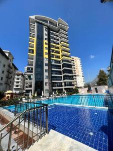 una piscina frente a un edificio alto en Aydemir park Mahmutlar 2, en Alanya