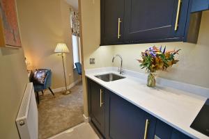 a kitchen with a sink and a vase of flowers at Moat House in Rawtenstall