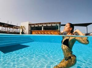 uma mulher num fato de sereia sentada numa piscina em Atermono Boutique Resort & Spa em Platanes