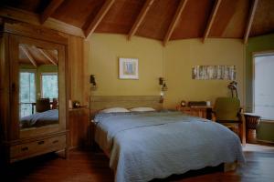 1 dormitorio con cama y espejo grande en Panorama Hut en Groesbeek