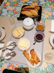 a tray of food with cheese and bread on a table at Chambre et table d'hôtes La Meule in Poligny