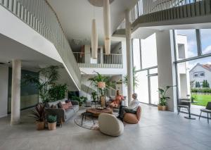 dos personas sentadas en el vestíbulo de un edificio en Hotel HegiQ, en Hegykő