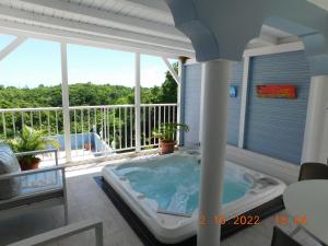 a hot tub in a room with a balcony at Les Hauts de Sainte-Anne "2 Spas privatifs" in Sainte-Anne +29 photos