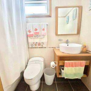 a bathroom with a white toilet and a sink at 3 Bedrooms At Marbella Beachfront Juan Dolio in Juan Dolio