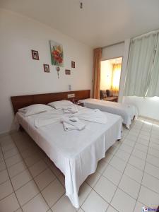 um quarto de hotel com duas camas e uma janela em CTC Araras Centro em Caldas Novas