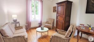 uma sala de estar com cadeiras, uma mesa e uma secretária em AU FIL DE L'EAU em Milly-sur-Thérain