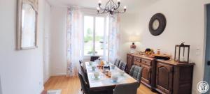 uma sala de jantar com mesa e cadeiras e um relógio em AU FIL DE L'EAU em Milly-sur-Thérain