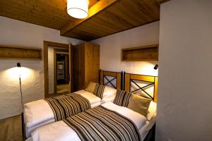 two beds in a room with two lamps on the wall at Cardinal Jasna Mountain Wellness Apartment in Demanovska Dolina