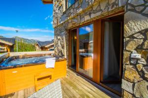 bañera de hidromasaje en la cubierta de una casa en Cardinal Jasna Mountain Wellness Apartment en Demanovska Dolina