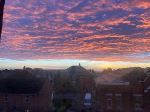a sunset in a city with houses and buildings at converted chapel filey floor to ceiling arch window in Filey