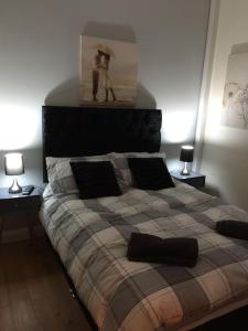 a bedroom with a large bed with two lamps at converted chapel filey floor to ceiling arch window in Filey
