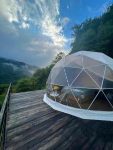 a wooden deck with a glass dome on it at Mtirala Glamping in Ch'ak'vist'avi